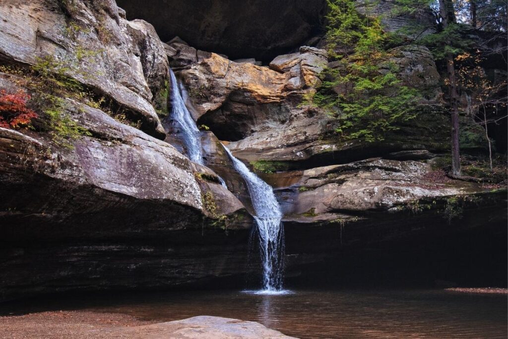 Waterfall spilling over rocks into a pool at Cedar Falls in Hocking Hills