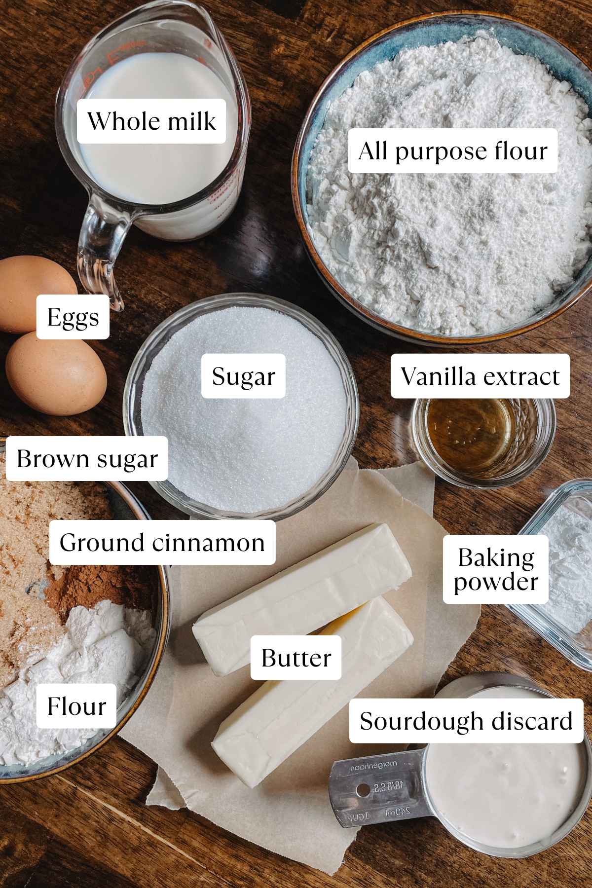 Flat lay of ingredients for sourdough discard coffee cake on a wooden table; ingredients are labeled