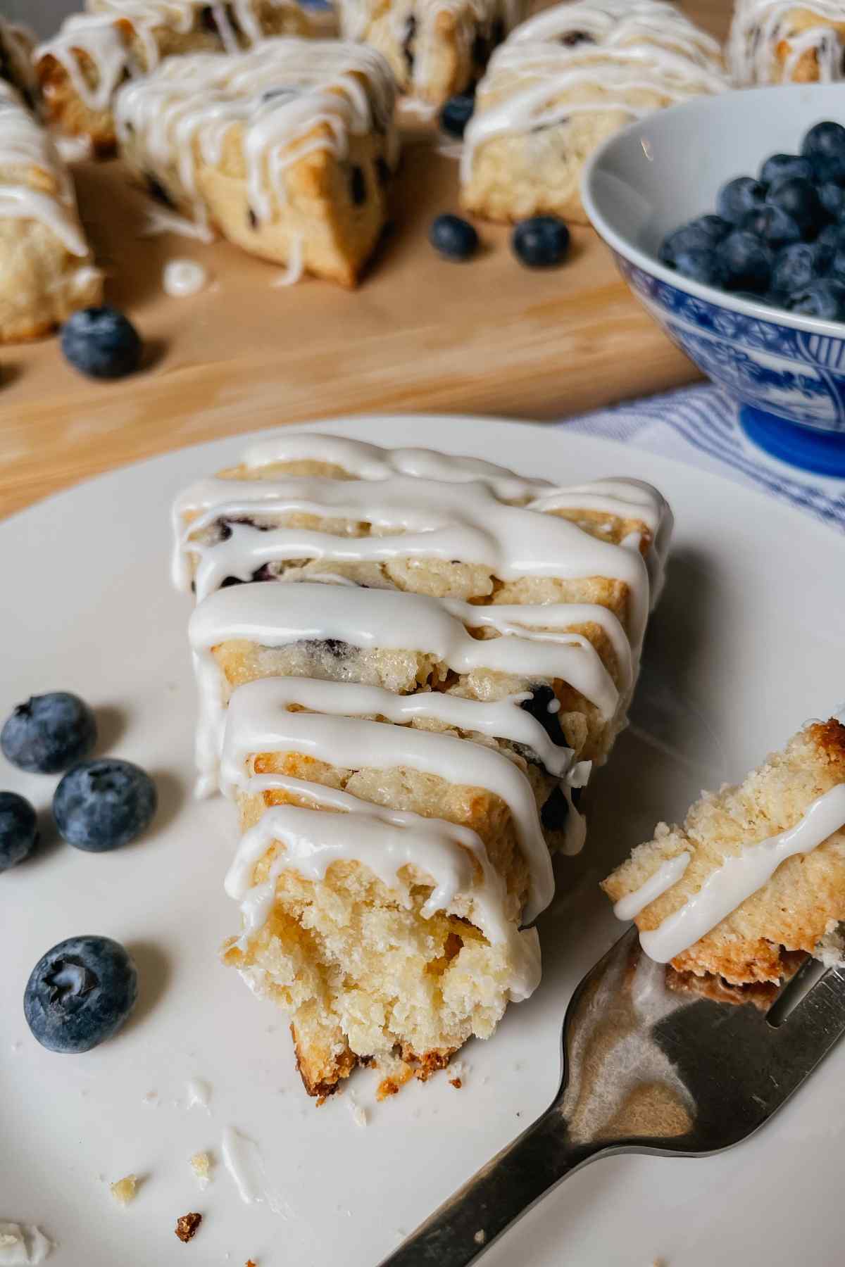 Sourdough blueberry scone on a white plate with a fork