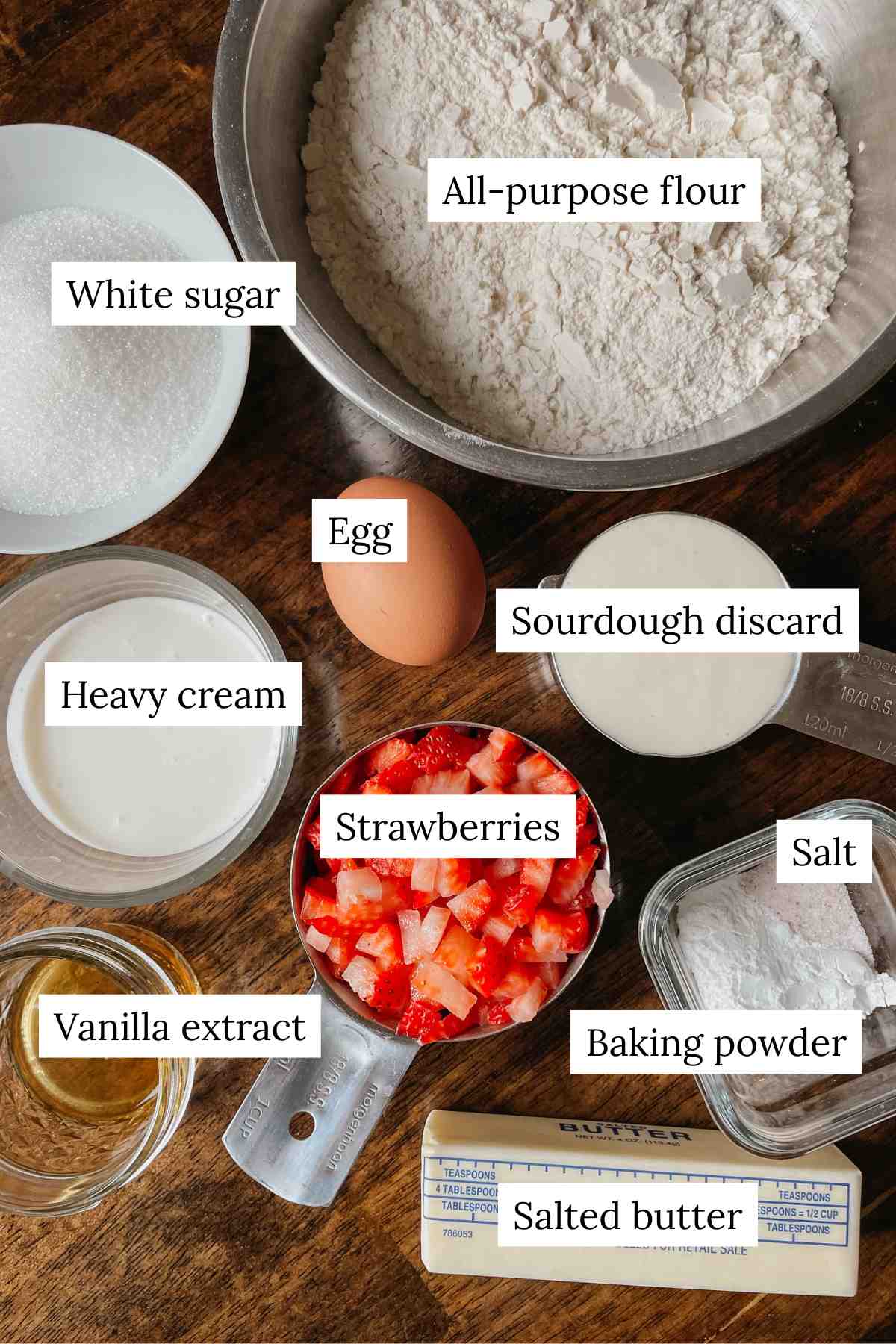 Ingredients for sourdough strawberry scones labeled on a wooden table