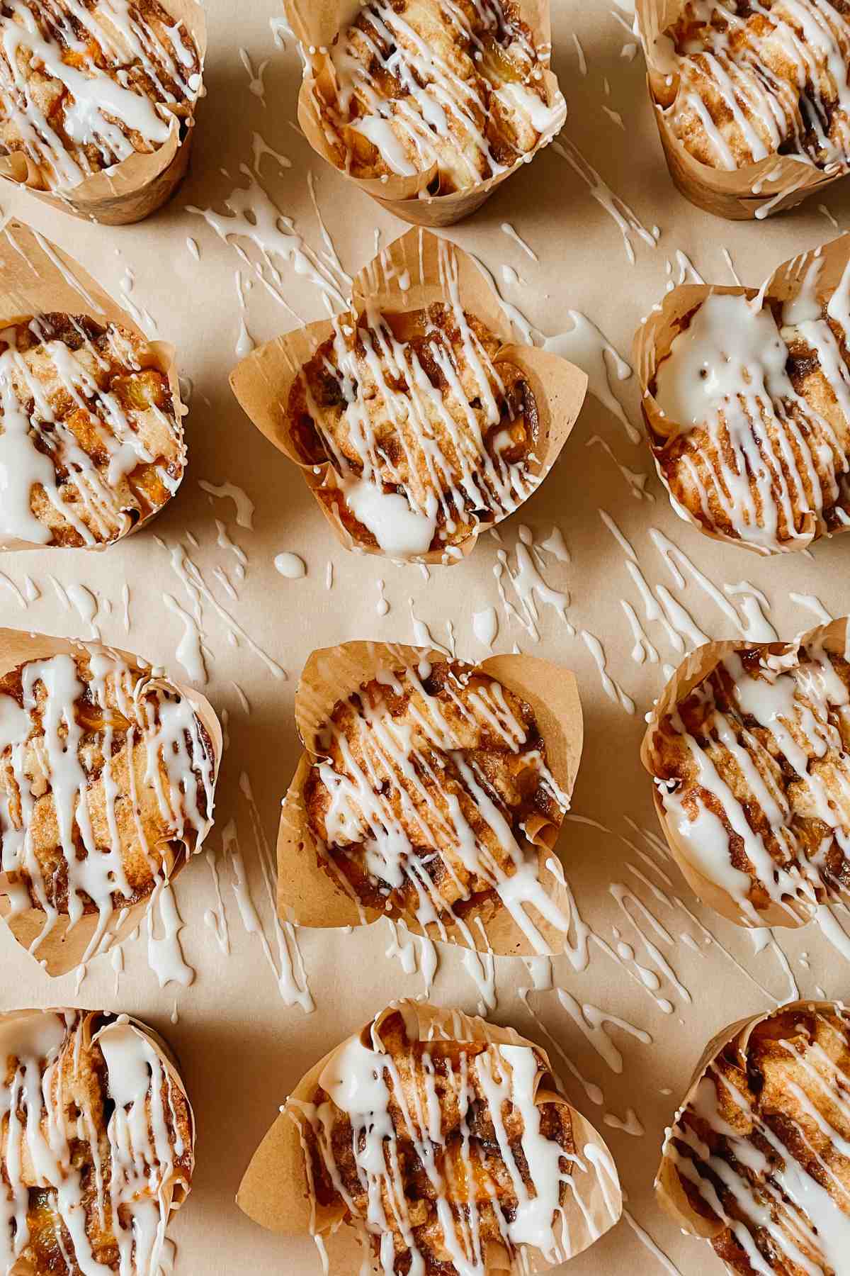 Sourdough peach coffee cake muffins drizzled with vanilla glaze