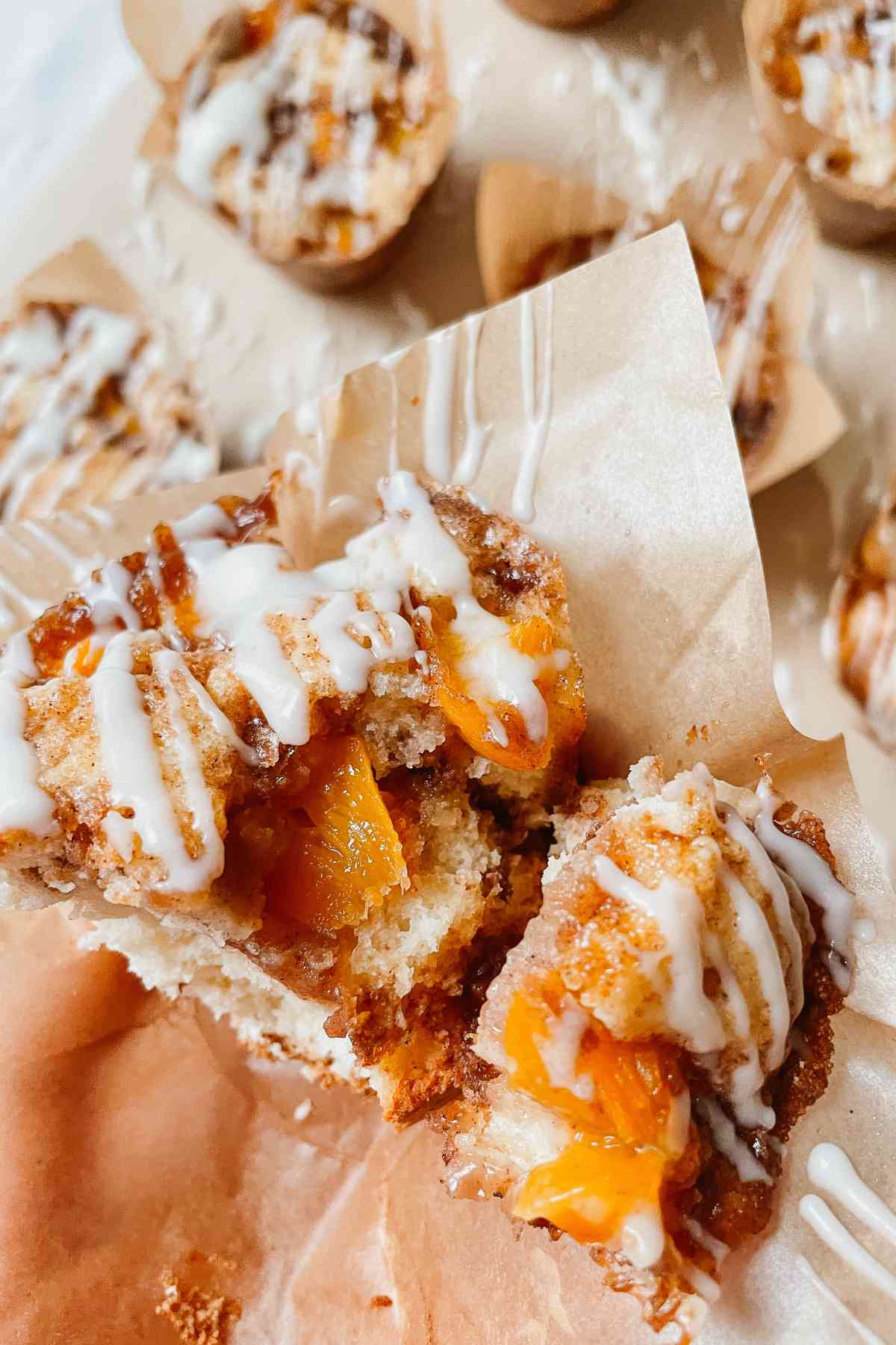 Sourdough peach coffee cake muffin drizzled with vanilla glaze