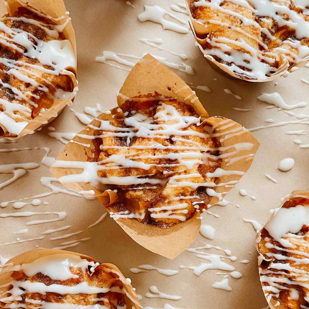 Sourdough peach coffee cake muffins drizzled with vanilla glaze