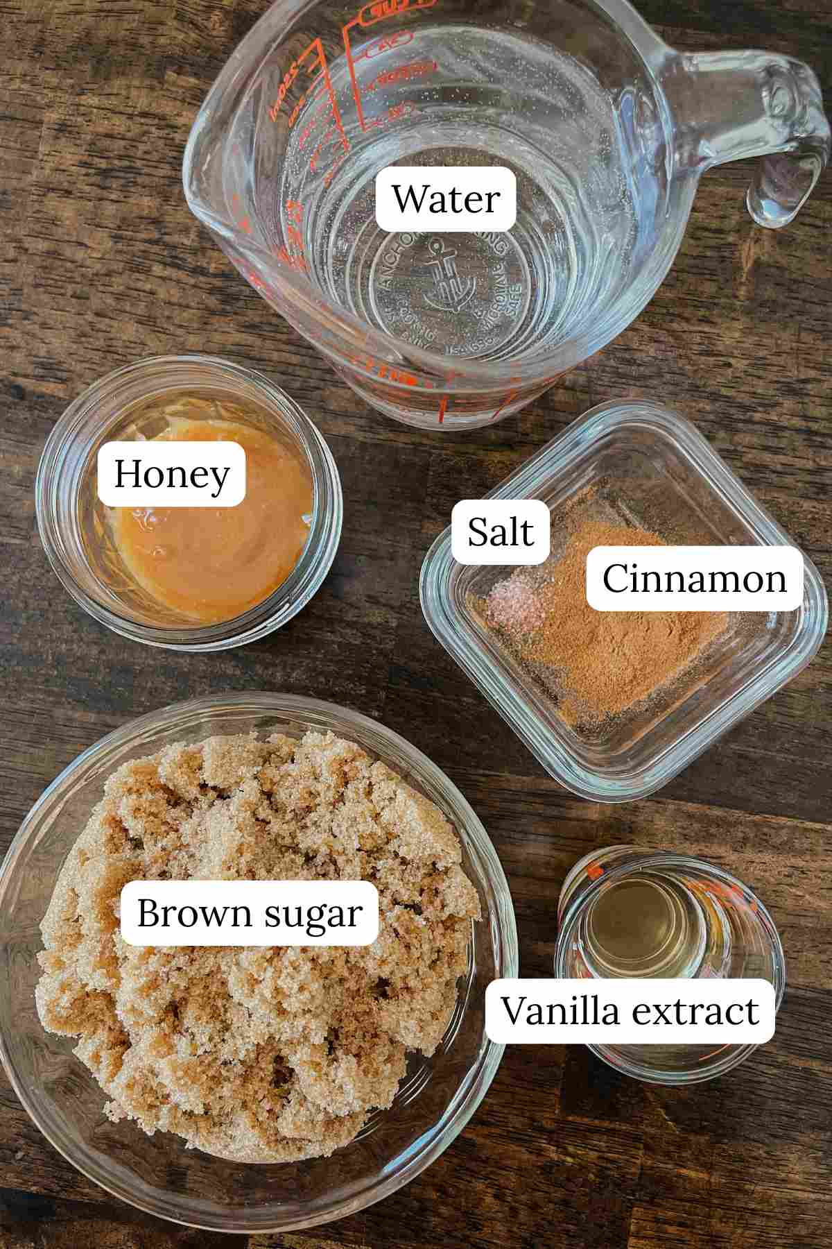 Ingredients for teddy graham latte coffee syrup in bowls labeled on wooden table