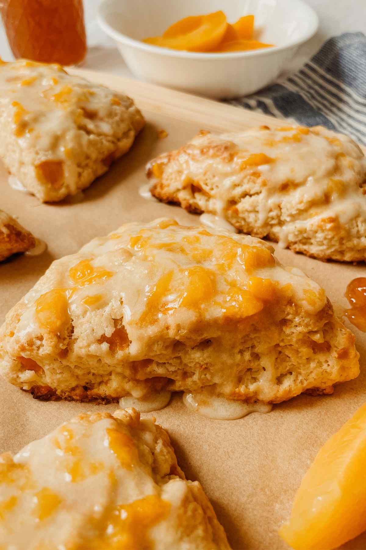 Close up of a sourdough peach scone drizzled with peach glaze