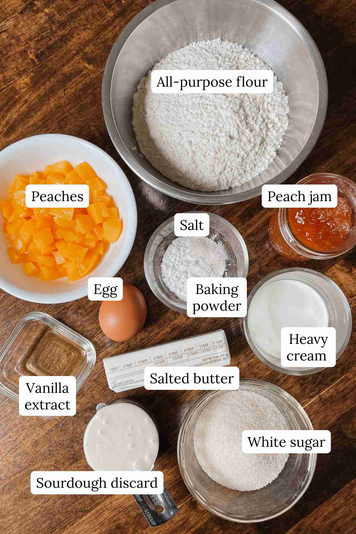 Ingredients for sourdough peach scones labeled on a wooden table