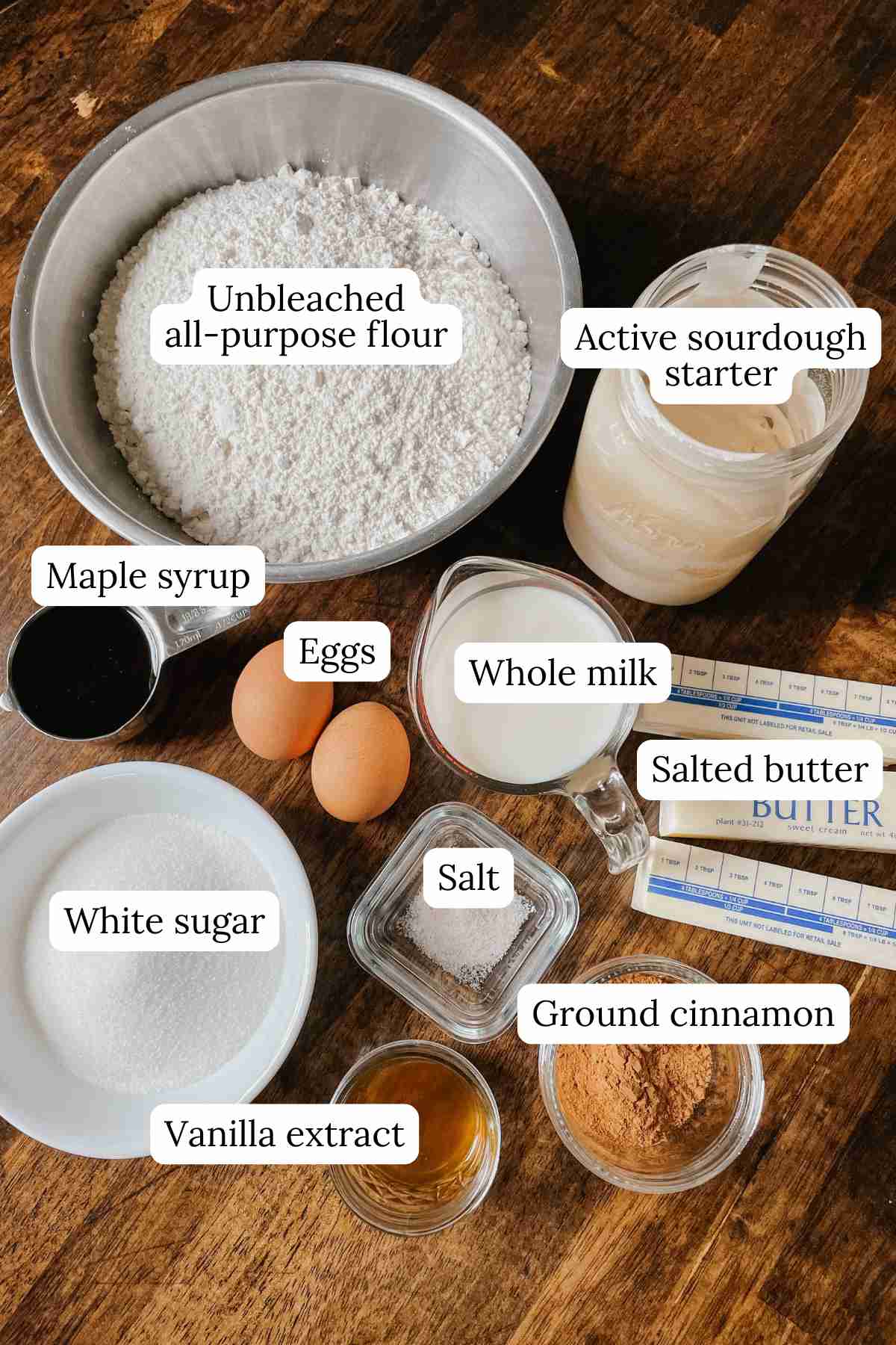 Sourdough monkey bread ingredients in bowls labeled on a wooden table