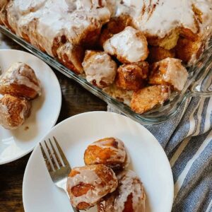 Sourdough brown butter monkey bread in pan and on white plate with a fork