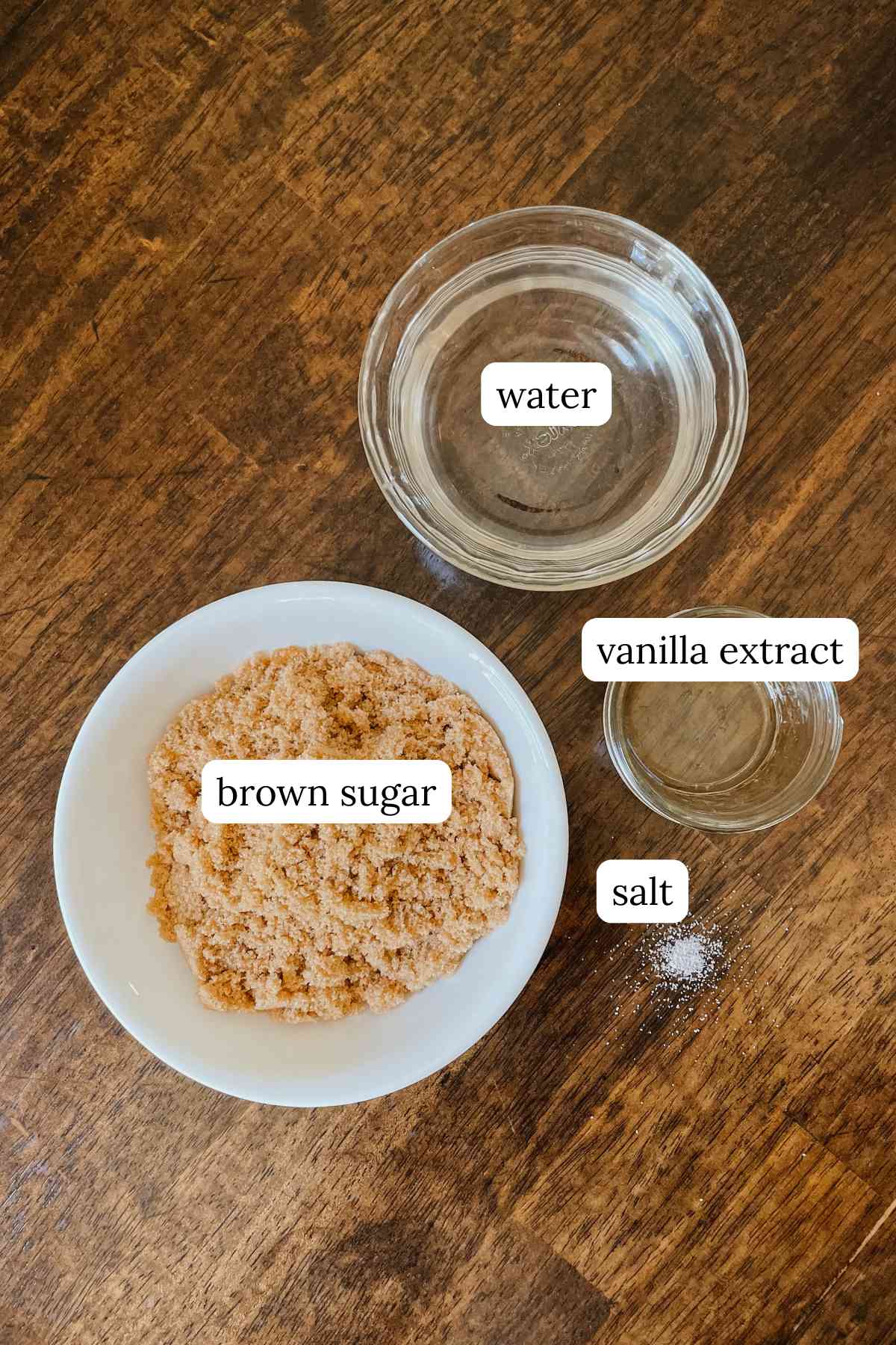 Ingredients for brown sugar coffee syrup labeled in bowls on a wooden table