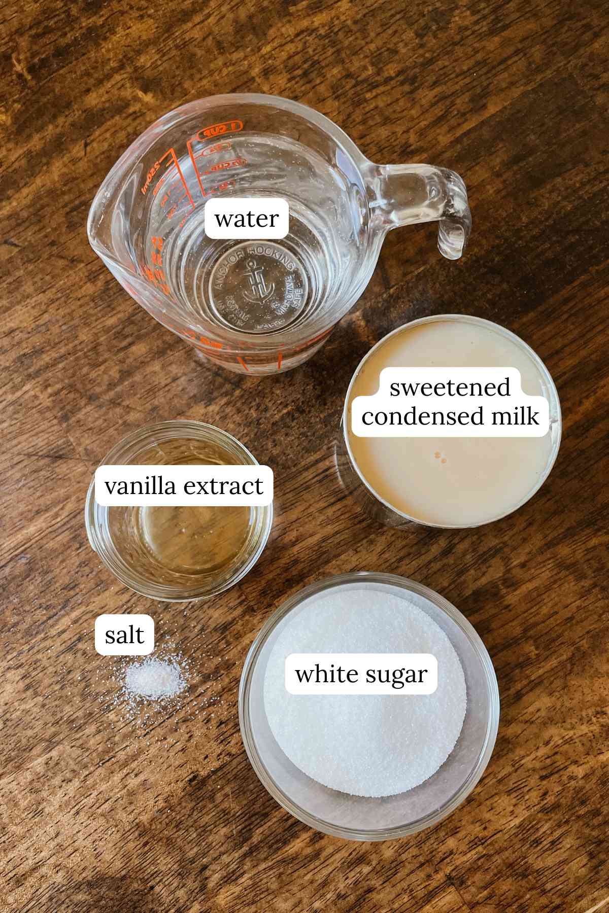 Ingredients for crème brûlée coffee syrup labeled in bowls on a wooden table