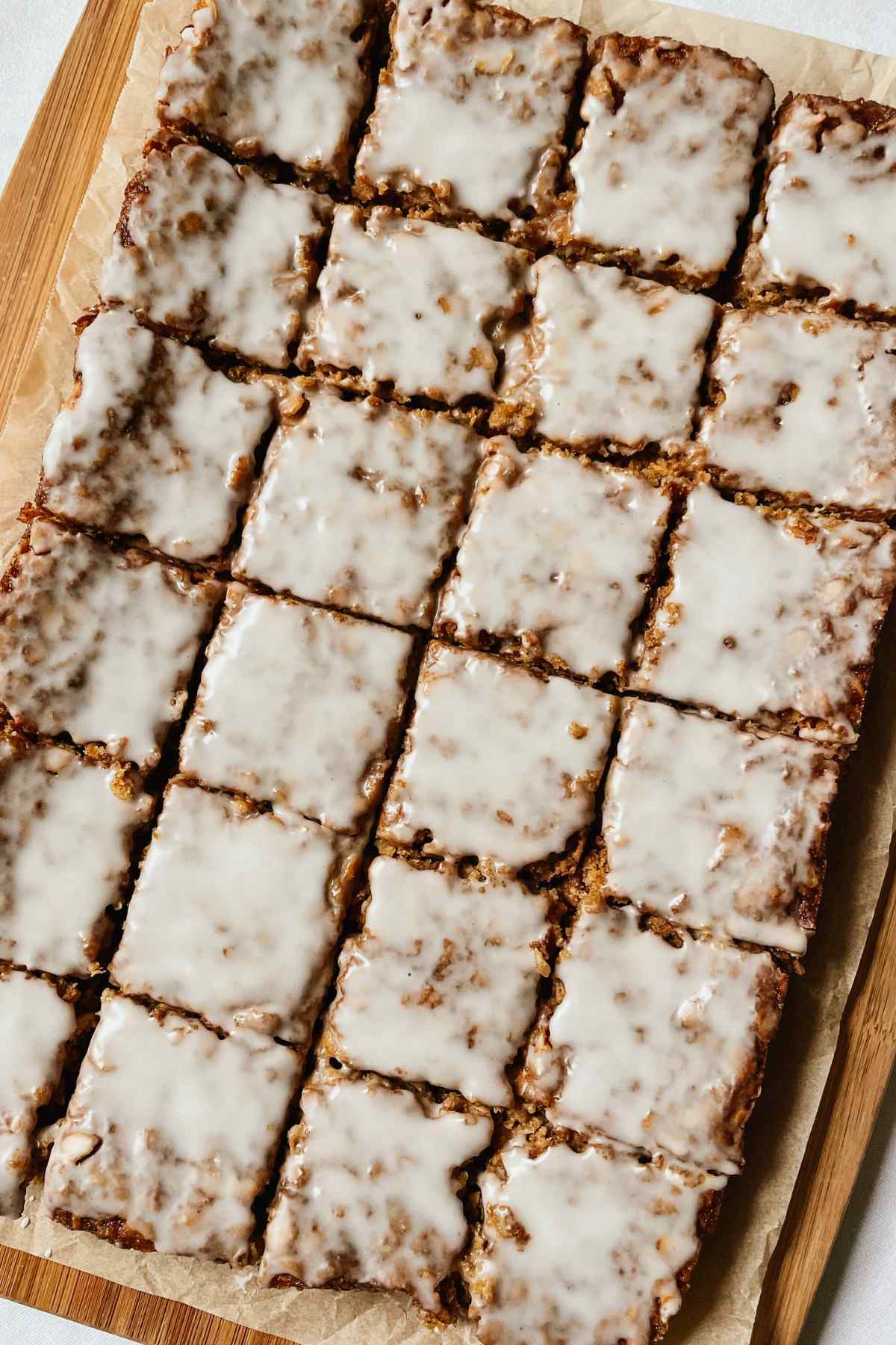 Sourdough oatmeal cookie bars with vanilla glaze icing on a wooden cutting board