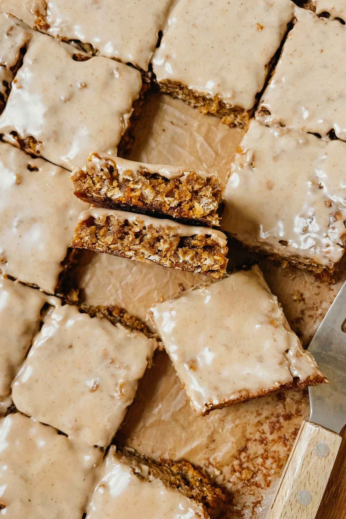 Sourdough gingerbread iced oatmeal cookie bar squares on parchment paper