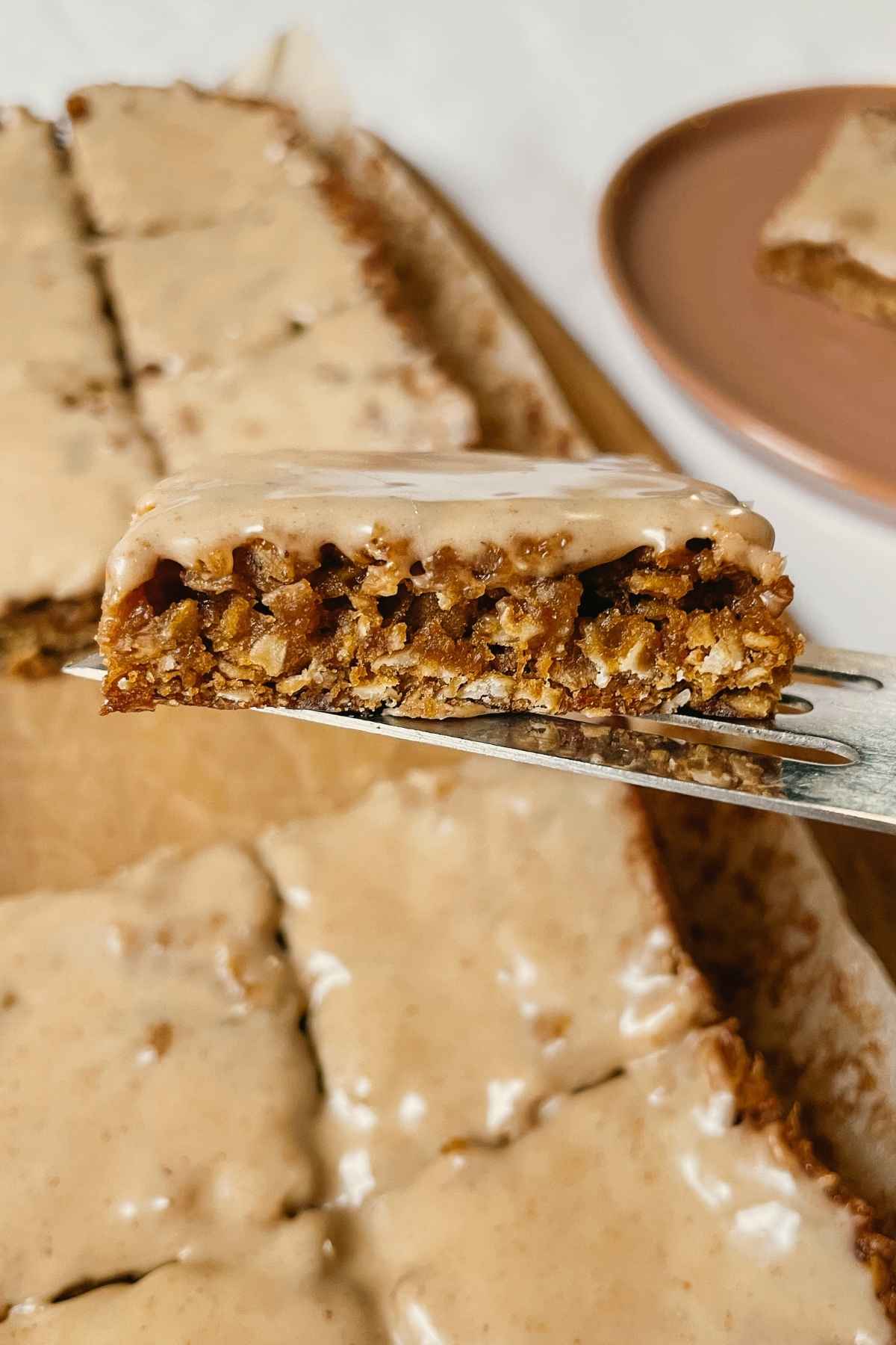 Serving utensil holding sourdough gingerbread iced oatmeal cookie bar squares