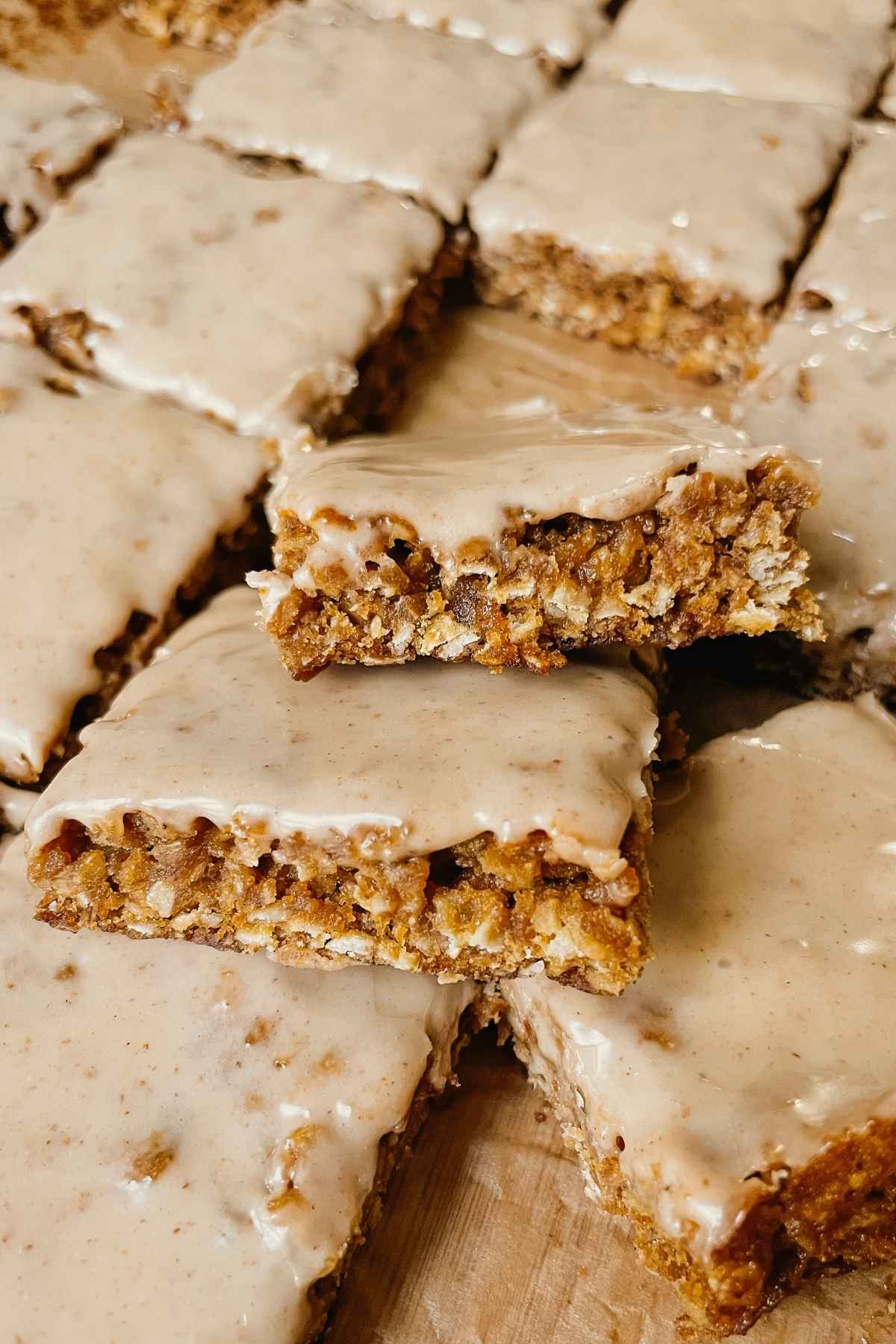 Sourdough gingerbread iced oatmeal cookie bar squares stacked on each other