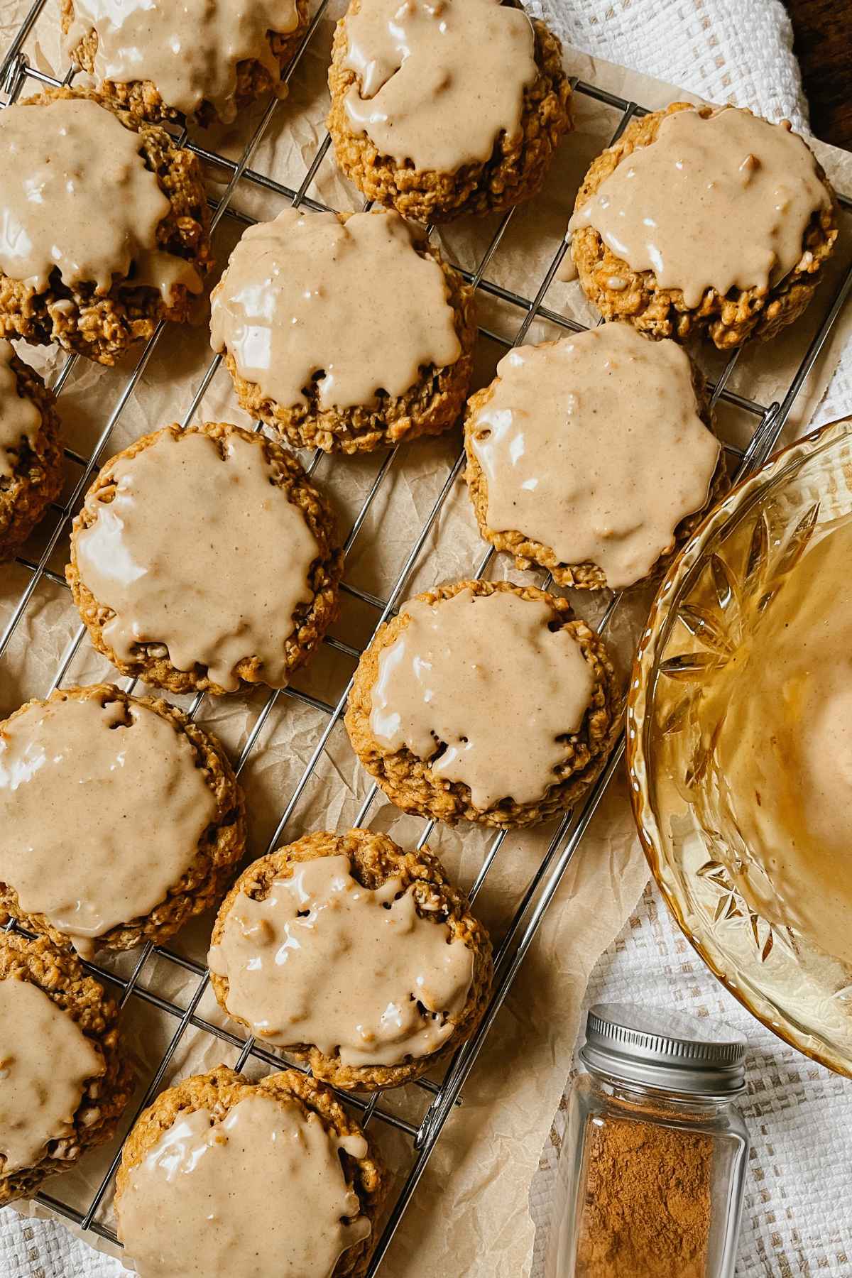 Sourdough pumpkin iced oatmeal cookies on wire cooling rack with white kitchen towel behind