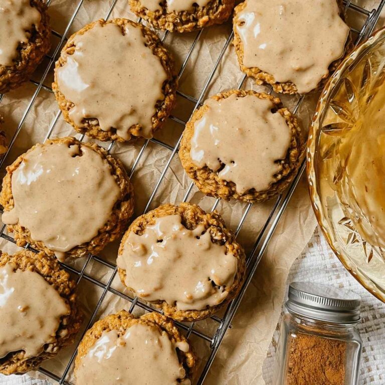 Sourdough pumpkin iced oatmeal cookies on wire cooling rack with white kitchen towel behind